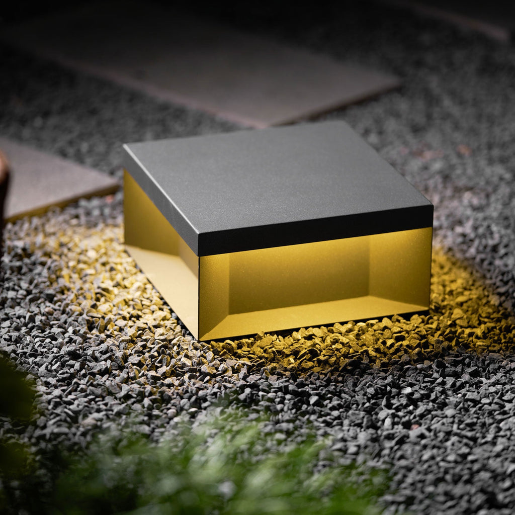Black post light lighting a courtyard entrance at dusk