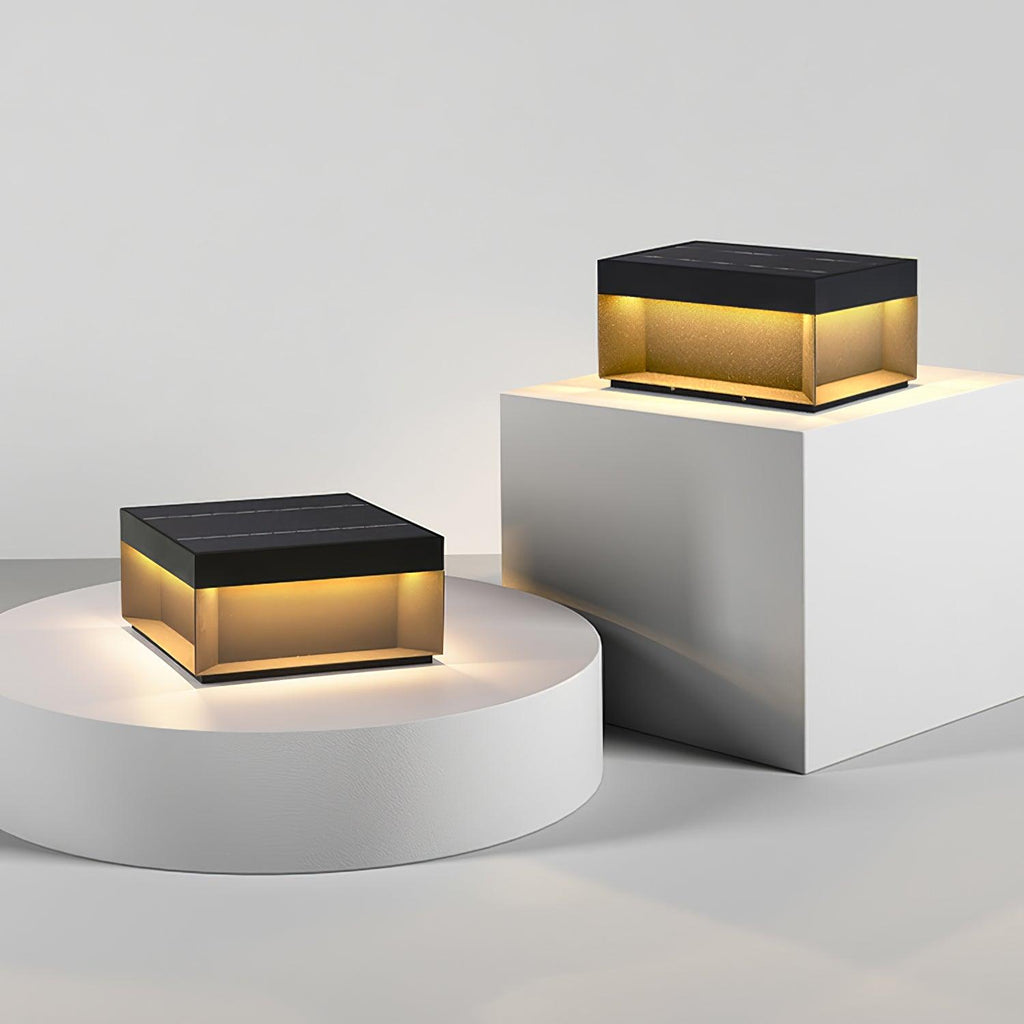 Square black post lamp lighting an outdoor walkway