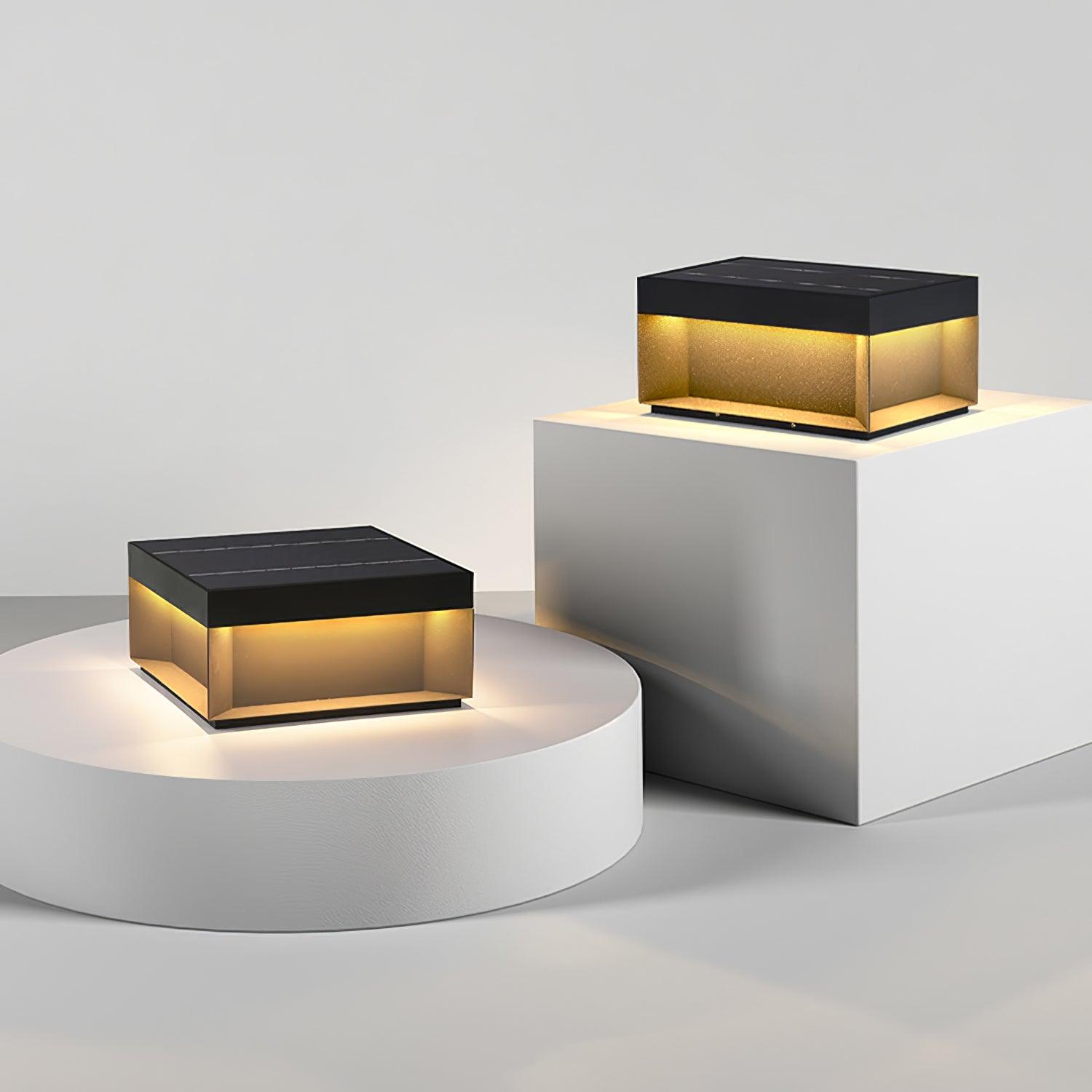 Square black post lamp lighting an outdoor walkway