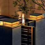 Boxy black post light with frosted shade along a path