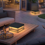 Black outdoor post lamp lighting a courtyard at night