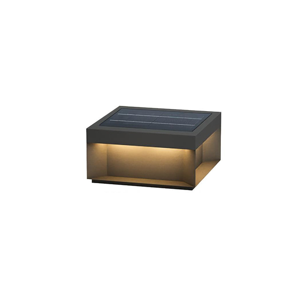 Black outdoor post light glowing softly among garden plants
