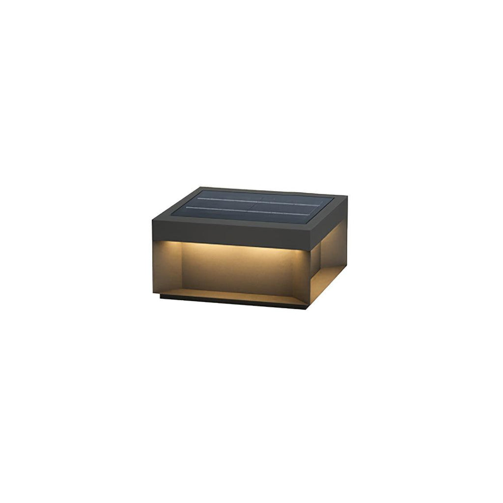 Boxy black post light glowing along a garden pathway at night