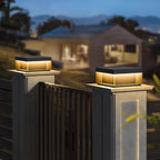 Black box post light illuminating a garden corner