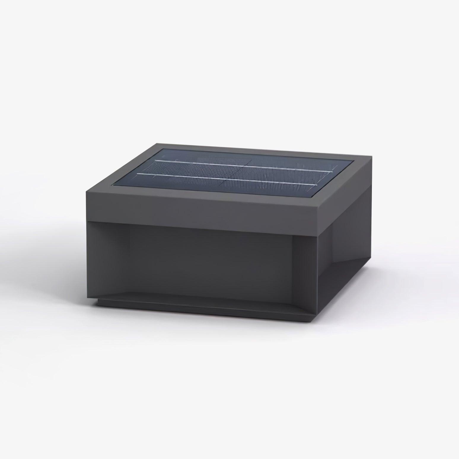 Square black post lamp lighting a paved outdoor area