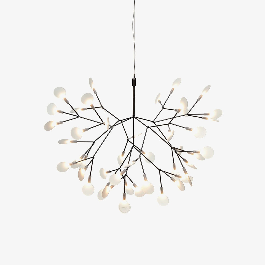 Black branch LED chandelier glowing warmly in a living room