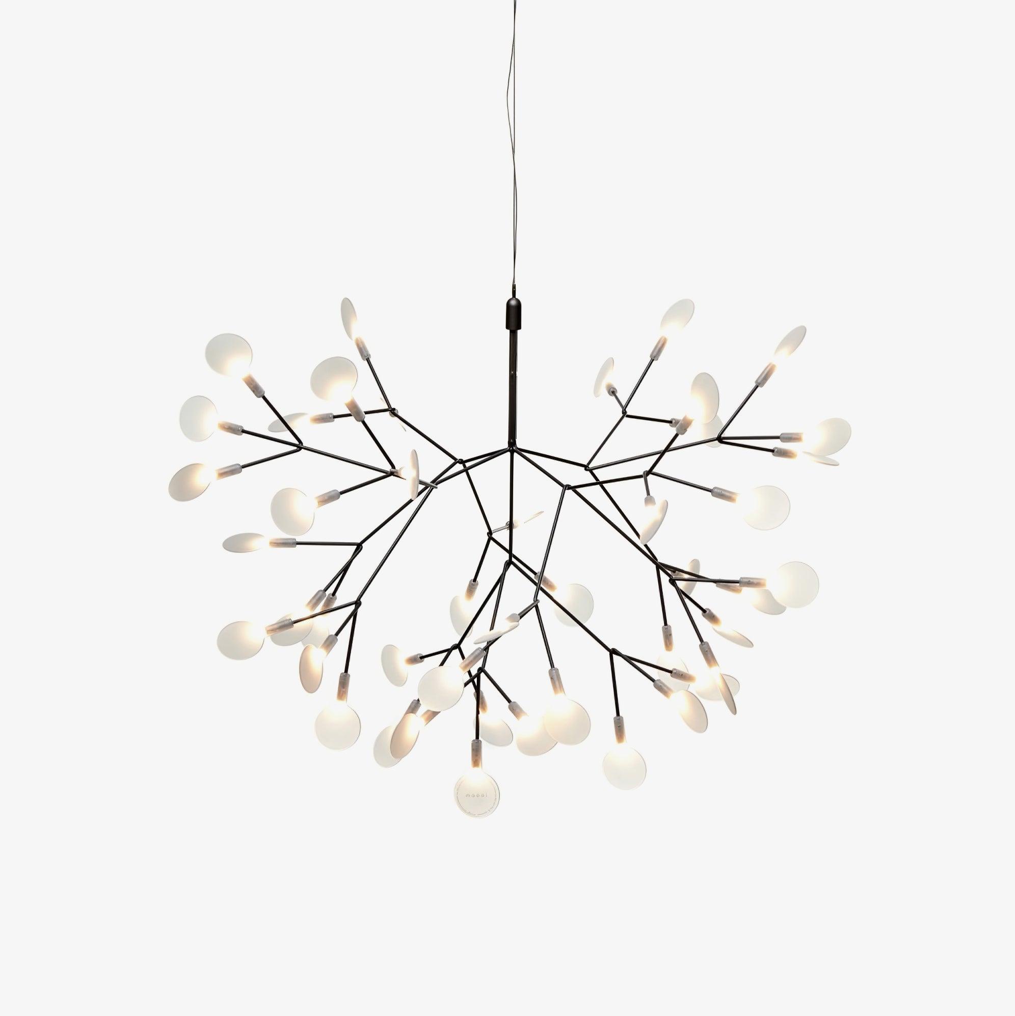Black branch LED chandelier glowing warmly in a living room