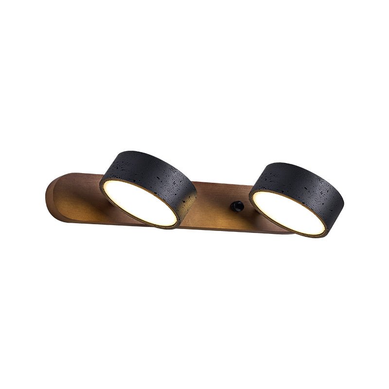 Black travertine wall sconce with walnut frame and warm light