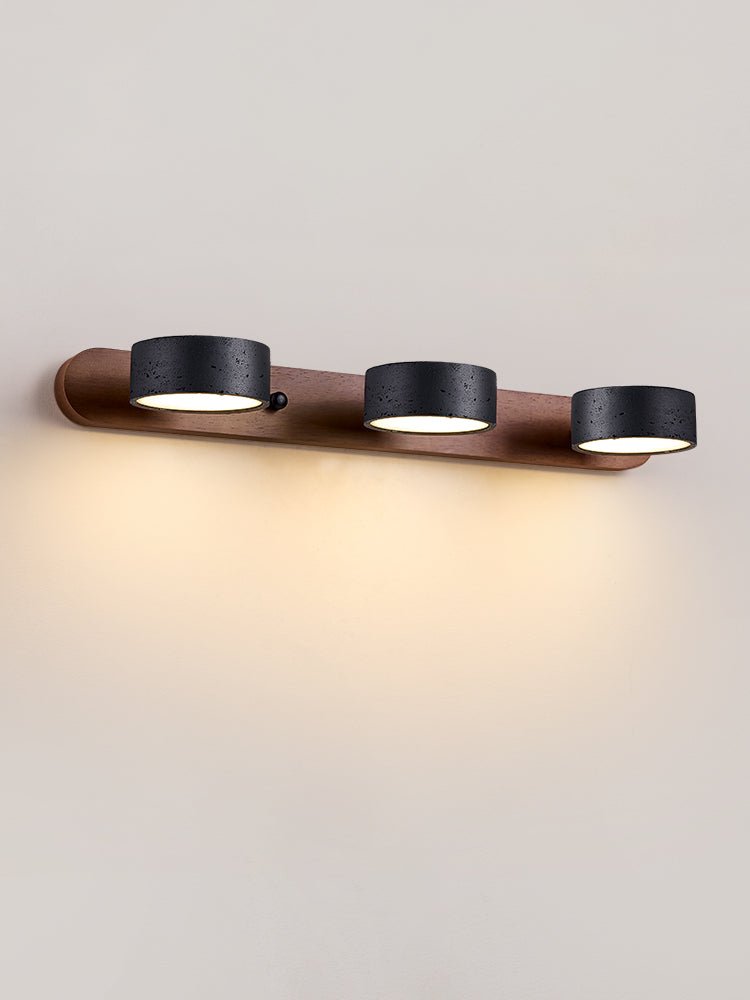 Black travertine wall sconce with four light heads on a wall