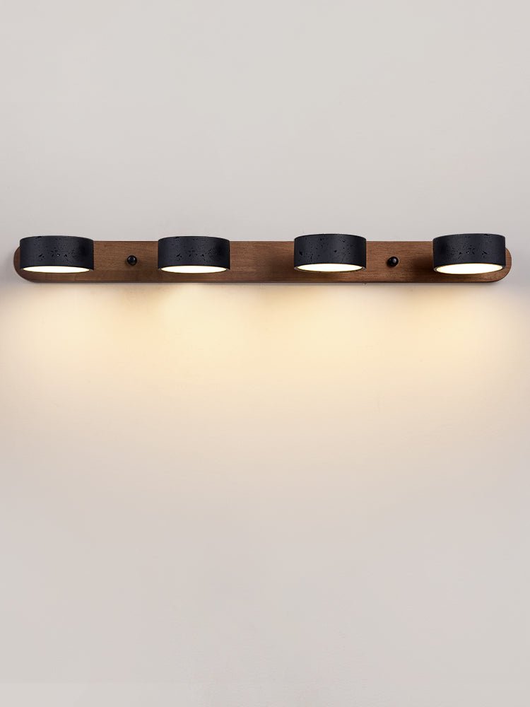 Black stone wall sconce glowing softly in a calm interior