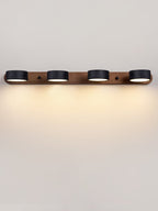 Black stone wall sconce glowing softly in a calm interior