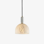A single dome pendant hangs against a plain white backdrop, its veined alabaster shade glowing warm on this Clérachic bedside light.