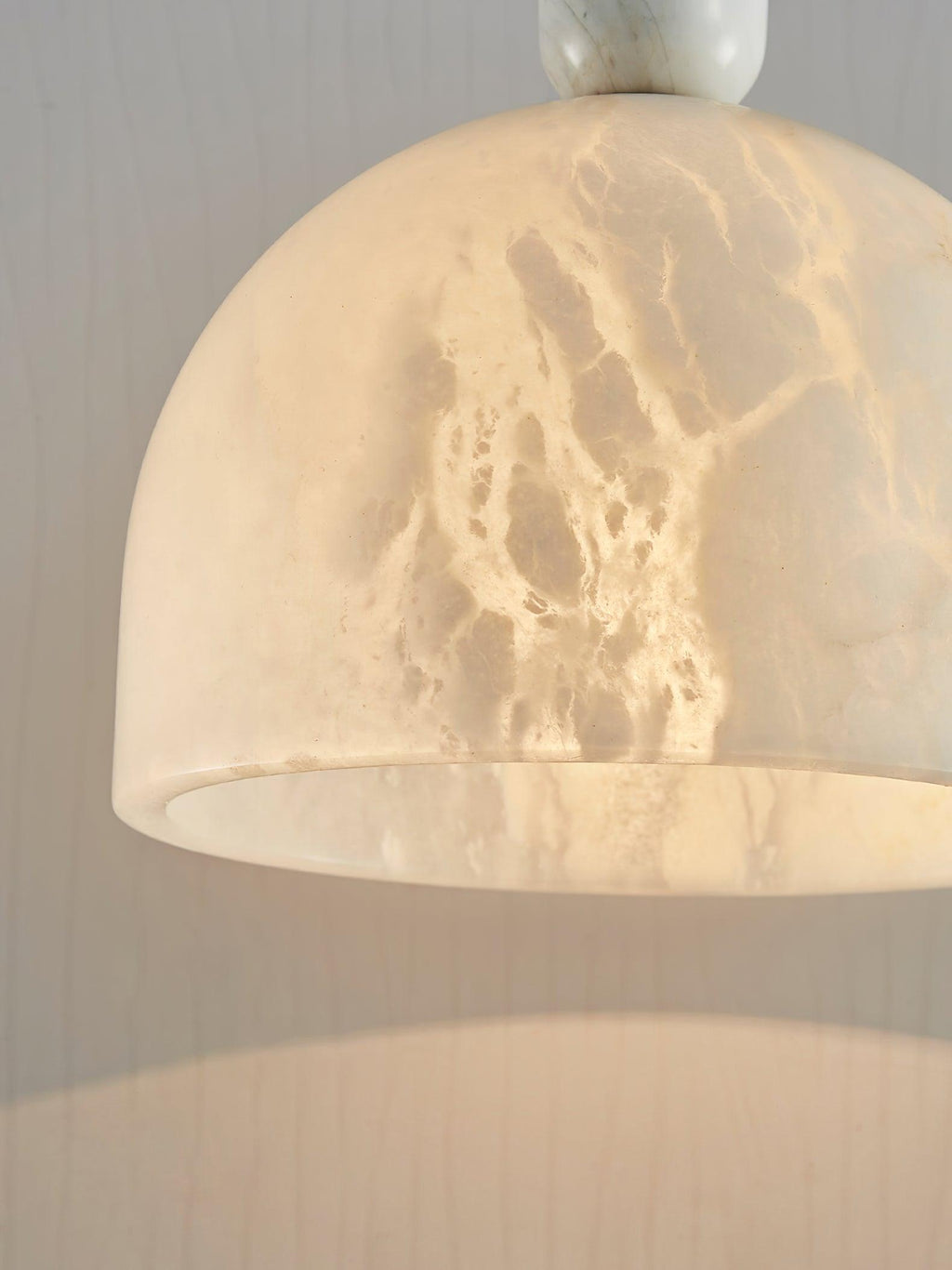 Extreme close-up looking up into the Clérachic alabaster shade, showing the natural stone veining and the rim's inner edge.
