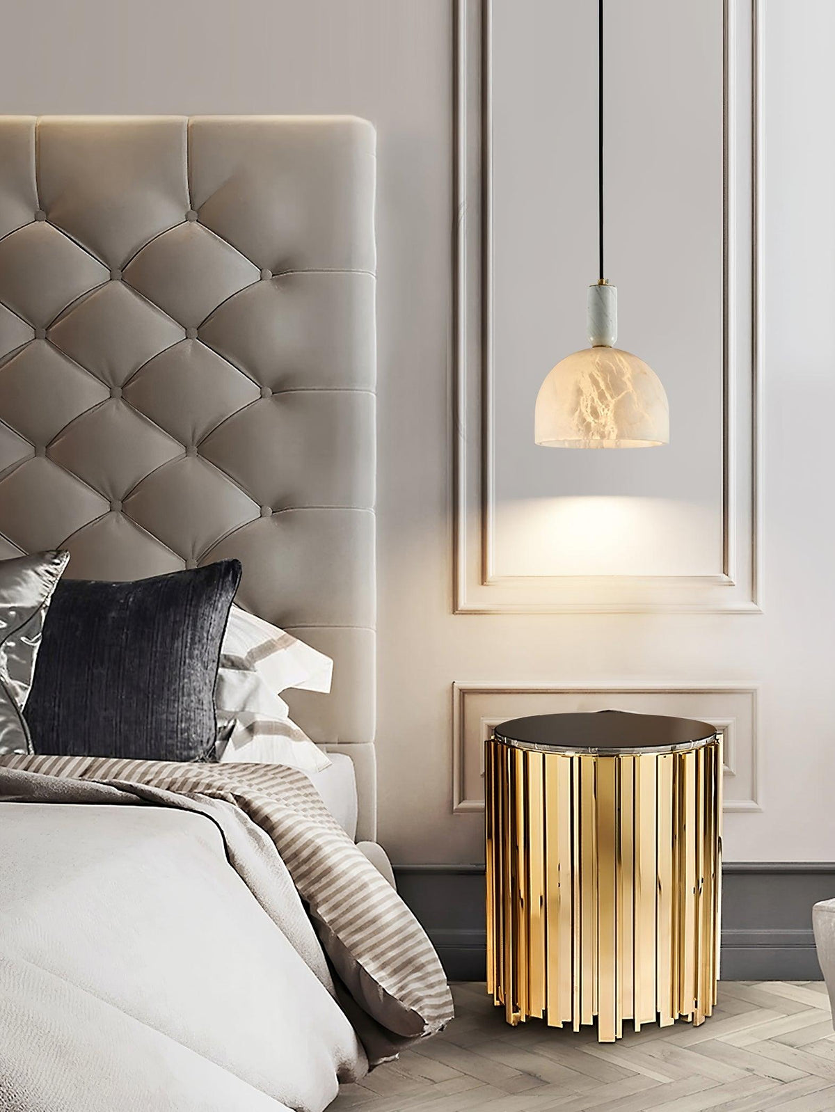 Clérachic alabaster pendant light beside a cream tufted headboard and a fluted gold side table, its dome lit a soft white.