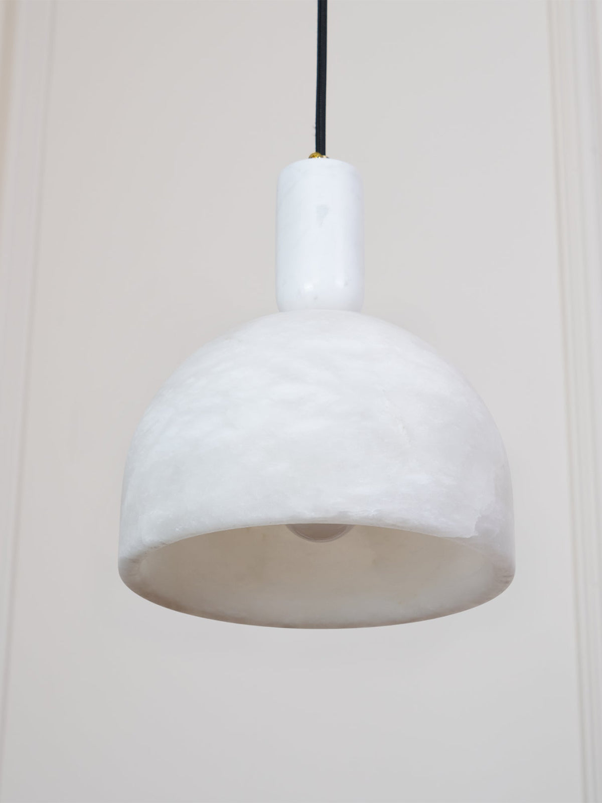 A tight crop from below shows the pale interior and rim of this Clérachic pendant, its brass fitting just visible above the unlit shade.
