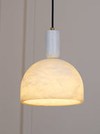 Hung near a panelled wall and switched on, this Clérachic alabaster dome glows amber above its brass neck and black cord.
