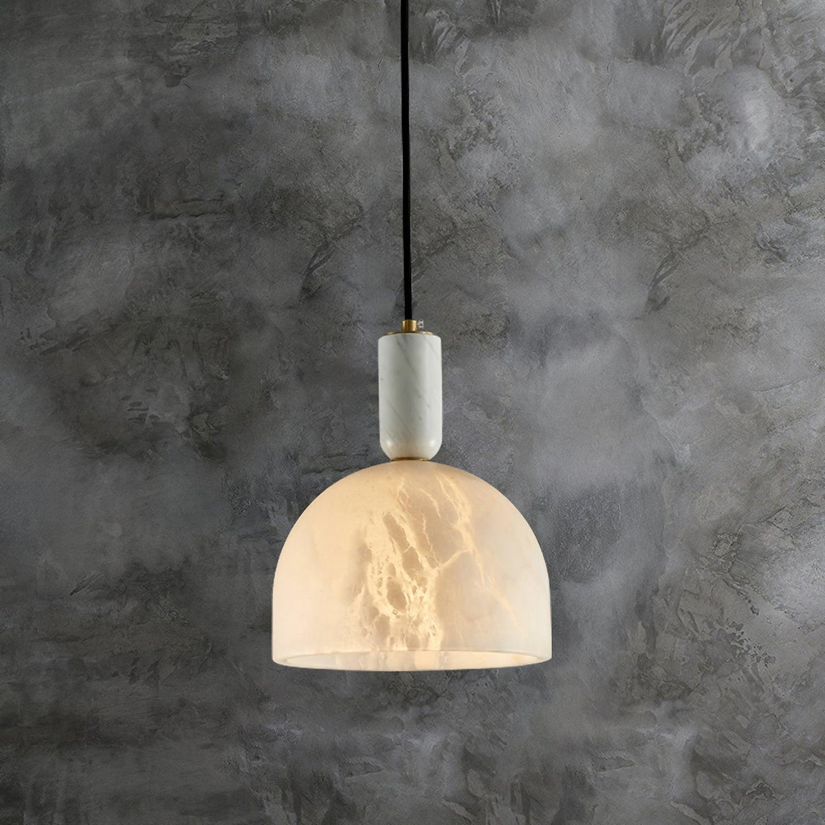 Clérachic alabaster pendant light hanging against a dark, mottled plaster wall, the cord and brass fitting clearly visible.