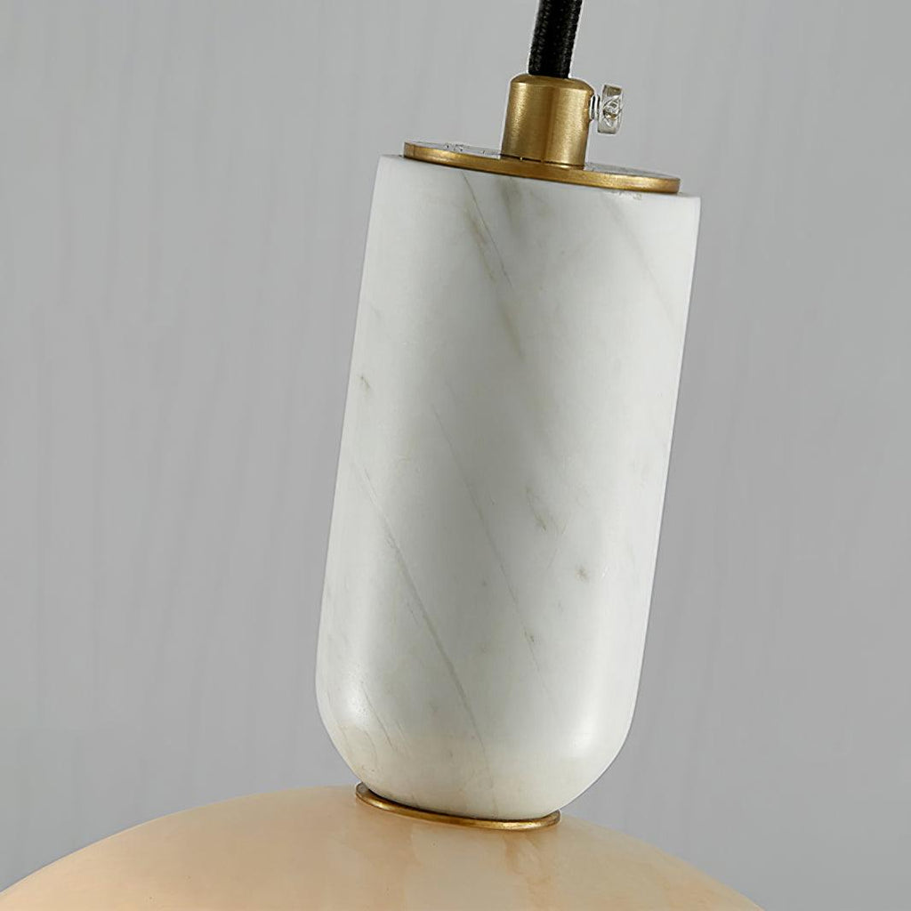 Macro shot of the Clérachic alabaster socket collar, showing where the brass fitting meets the veined stone neck.