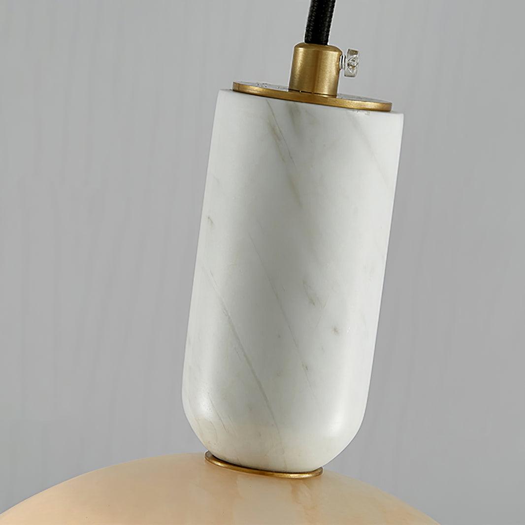 Macro shot of the Clérachic alabaster socket collar, showing where the brass fitting meets the veined stone neck.