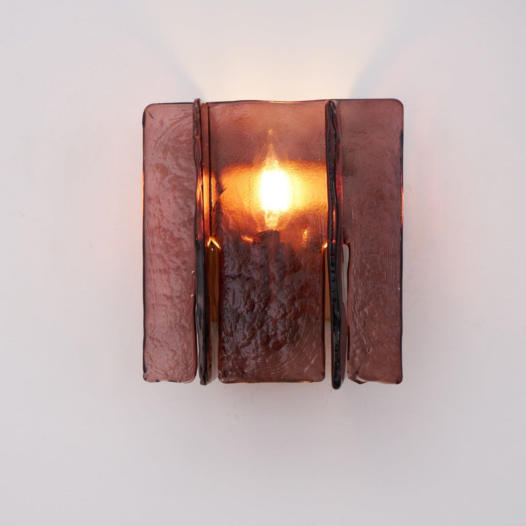 Brass wall sconce angled view with wine red glass accent