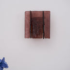 Lit brass wall sconce projecting dramatic light onto surrounding surfaces