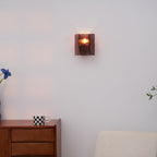 Close detail of brass wall sconce wine red glass shade