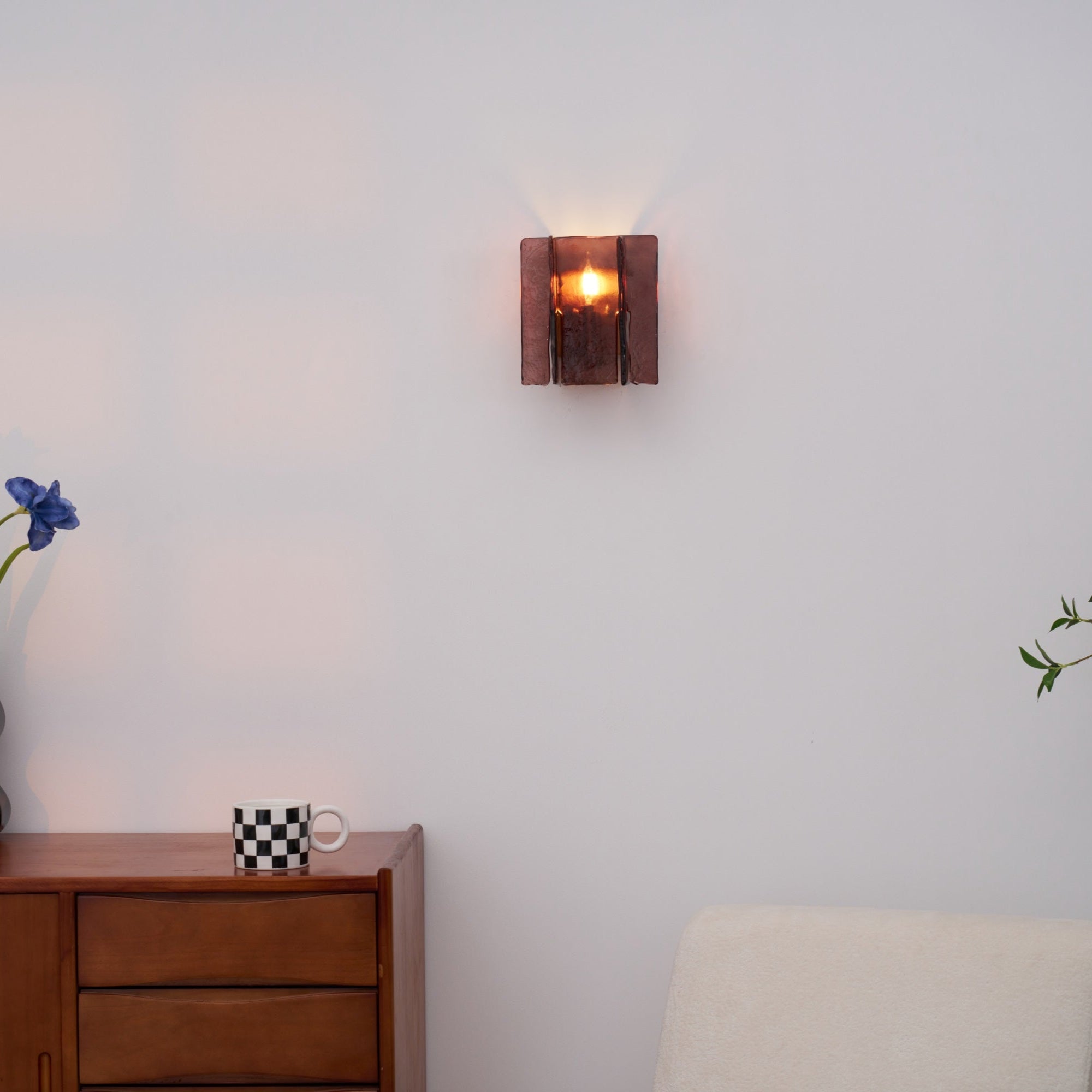 Close detail of brass wall sconce wine red glass shade