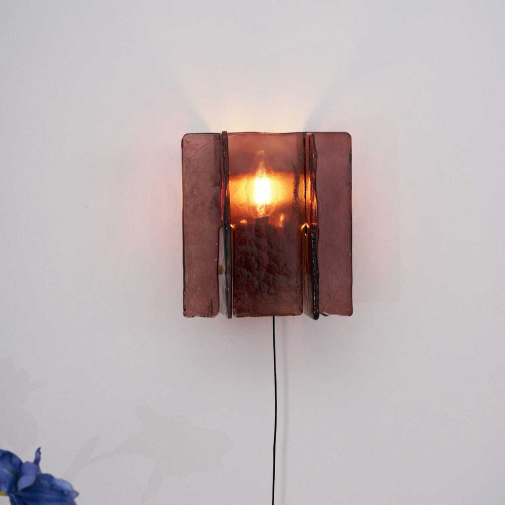 Wall sconce projecting dramatic red light patterns at night