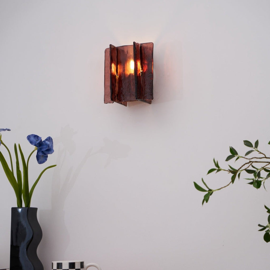 Brass wall sconce detail of gold frame and glass plates