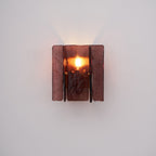 Gold brass wall sconce with wine red glass mounted on a wall