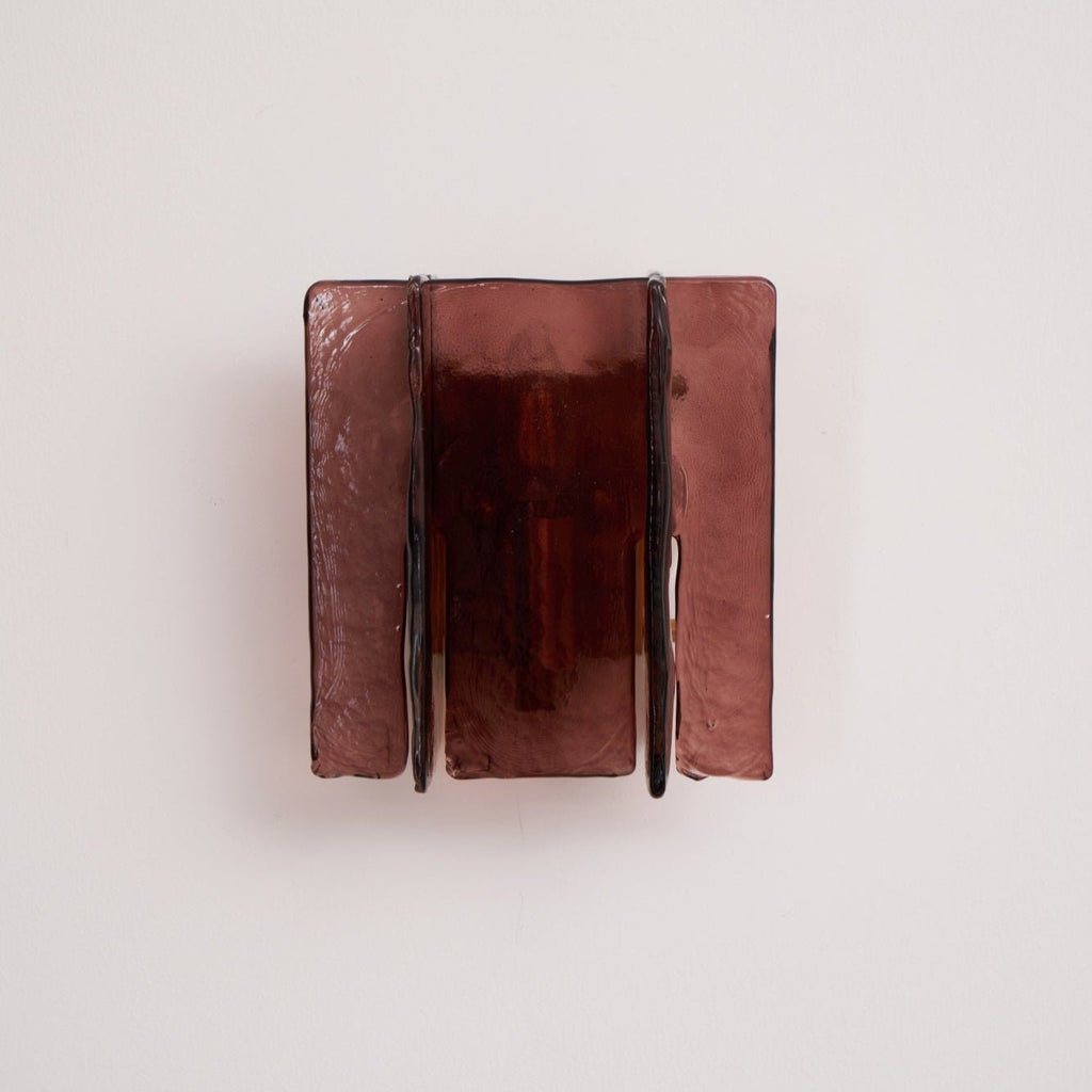 Brass wall sconce mounted on a wall in a styled interior