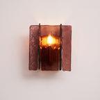 Brass wall sconce with wine red glass plates mounted on wall