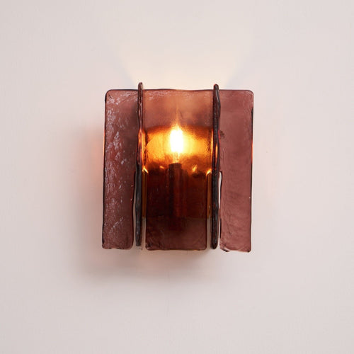 Brass wall sconce with wine red glass plates mounted on wall