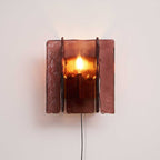 Brass plug-in wall sconce with wine-red glass plates lit up