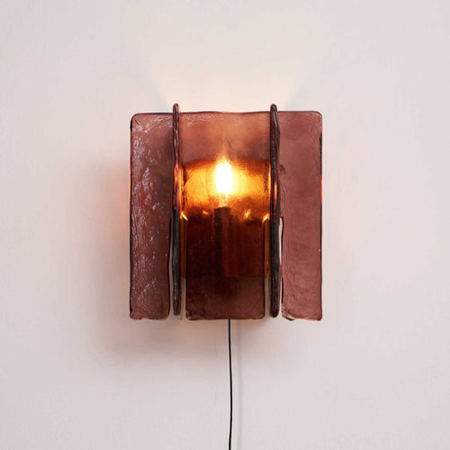 Brass plug-in wall sconce with wine-red glass plates lit up
