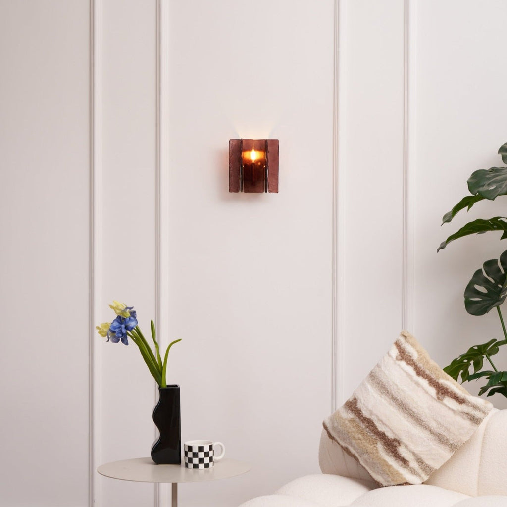 Brass wall sconce shown lit with warm candelabra bulb glow