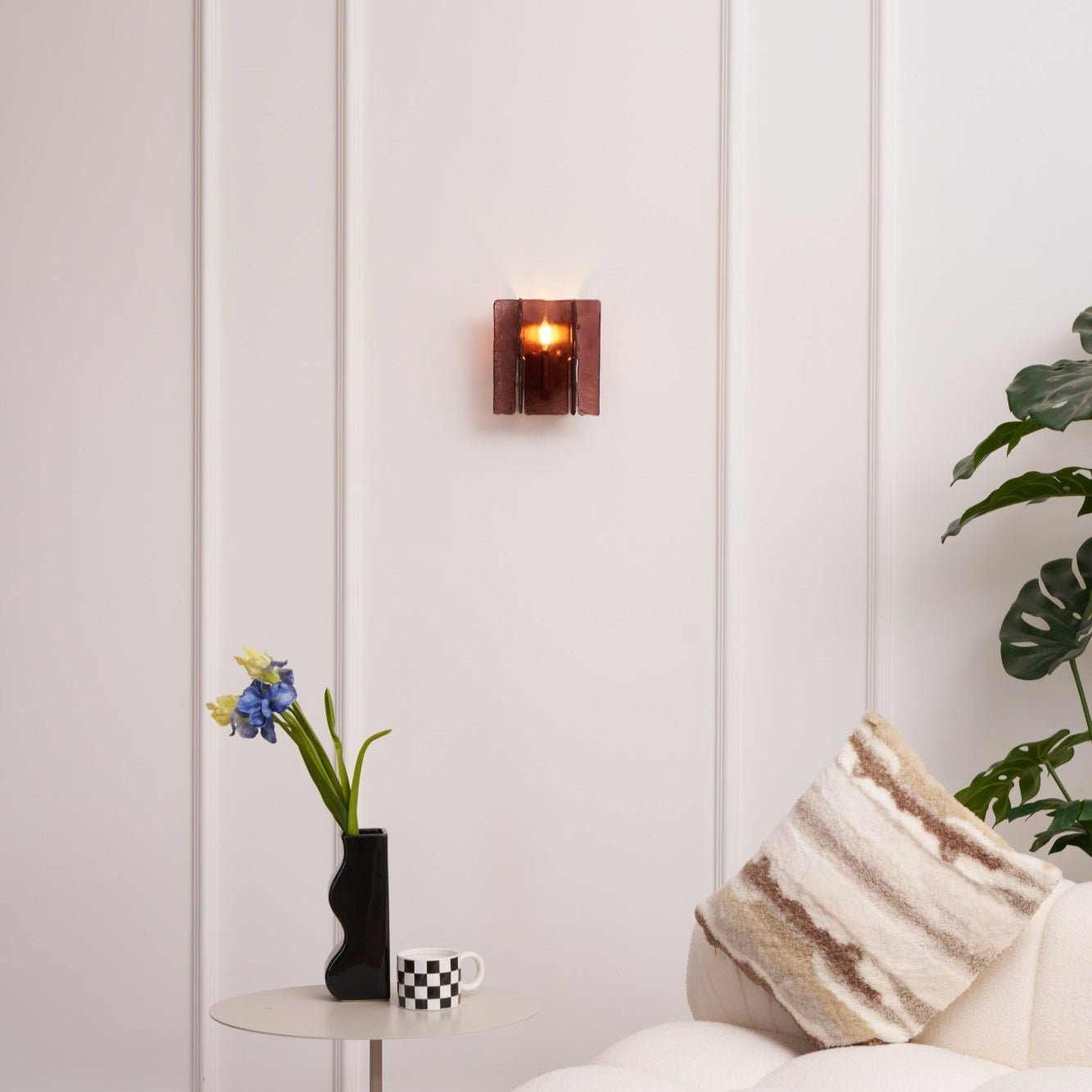Brass wall sconce shown lit with warm candelabra bulb glow