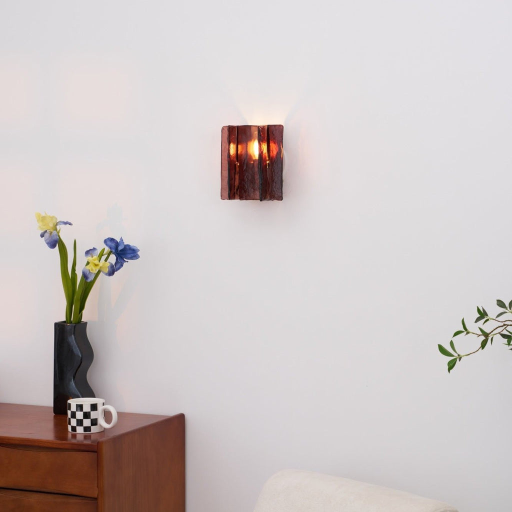 Brass wall sconce with wine red glass viewed straight on