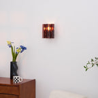 Brass wall sconce with wine red glass viewed straight on