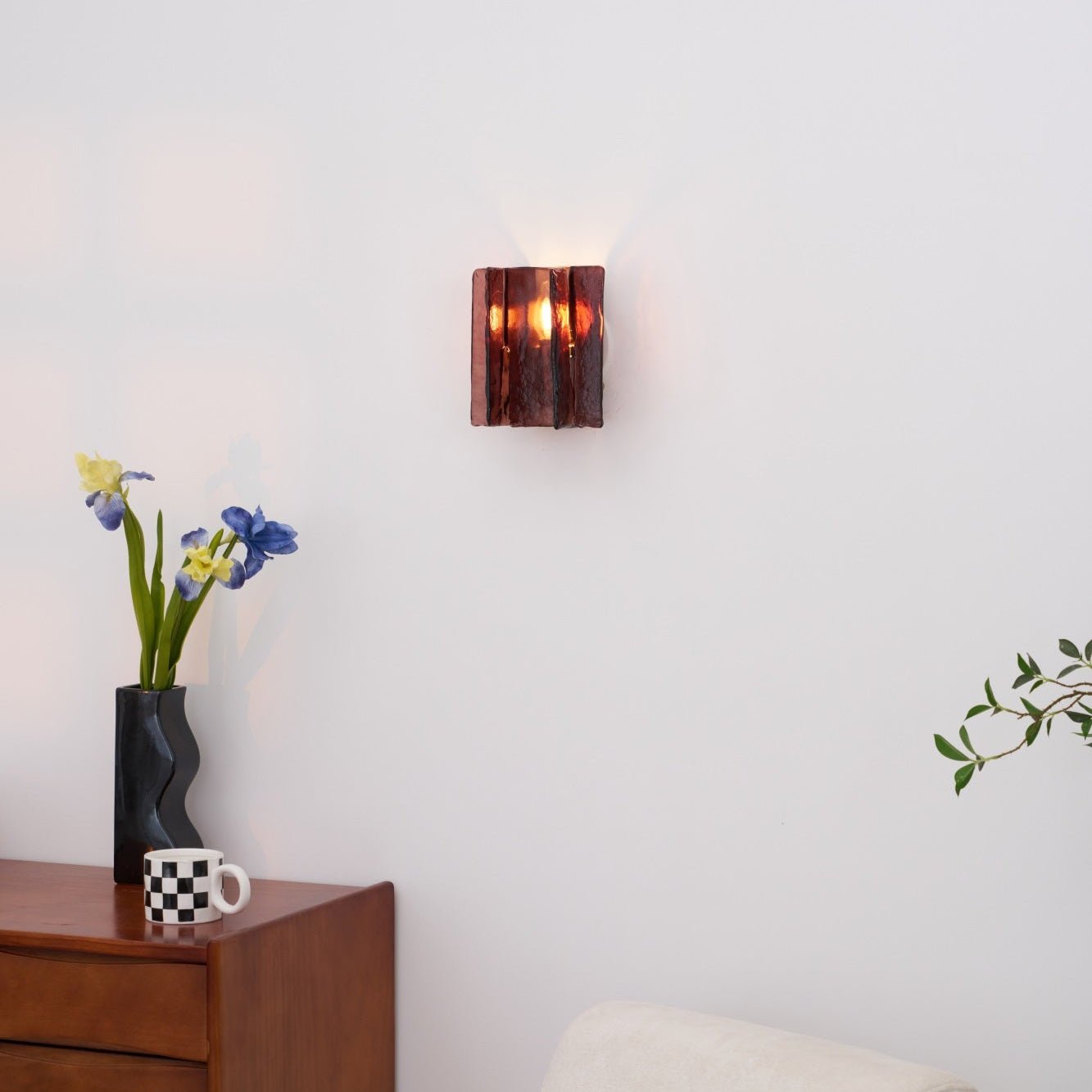 Brass wall sconce with wine red glass viewed straight on