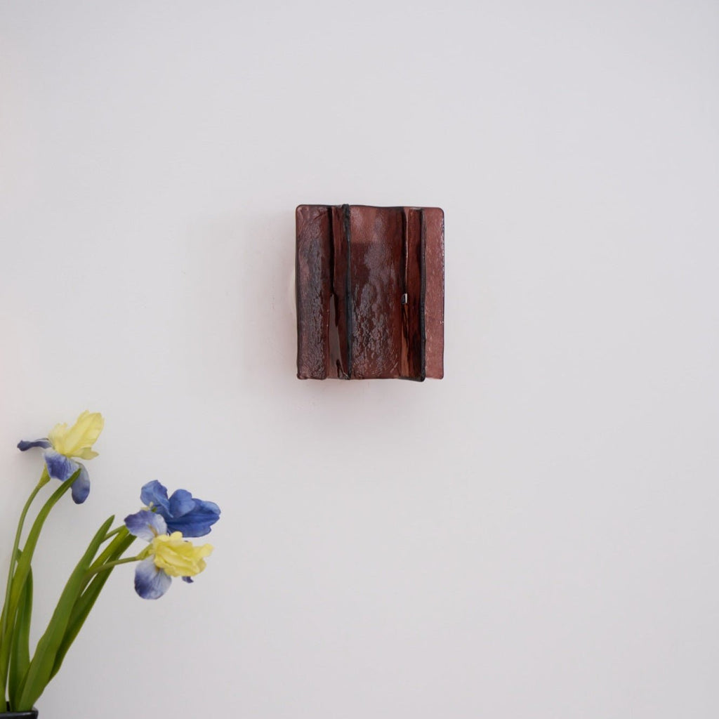 Brass wall sconce detail showing refracting clear glass plates