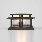 This lit Clérachic pillar light shows its fluted glass panels and mounting screws in the base, set against plain white.