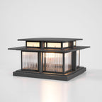 A three-quarter studio view of this lit Clérachic pillar light, fluted glass panels glowing above a screwed-down base.