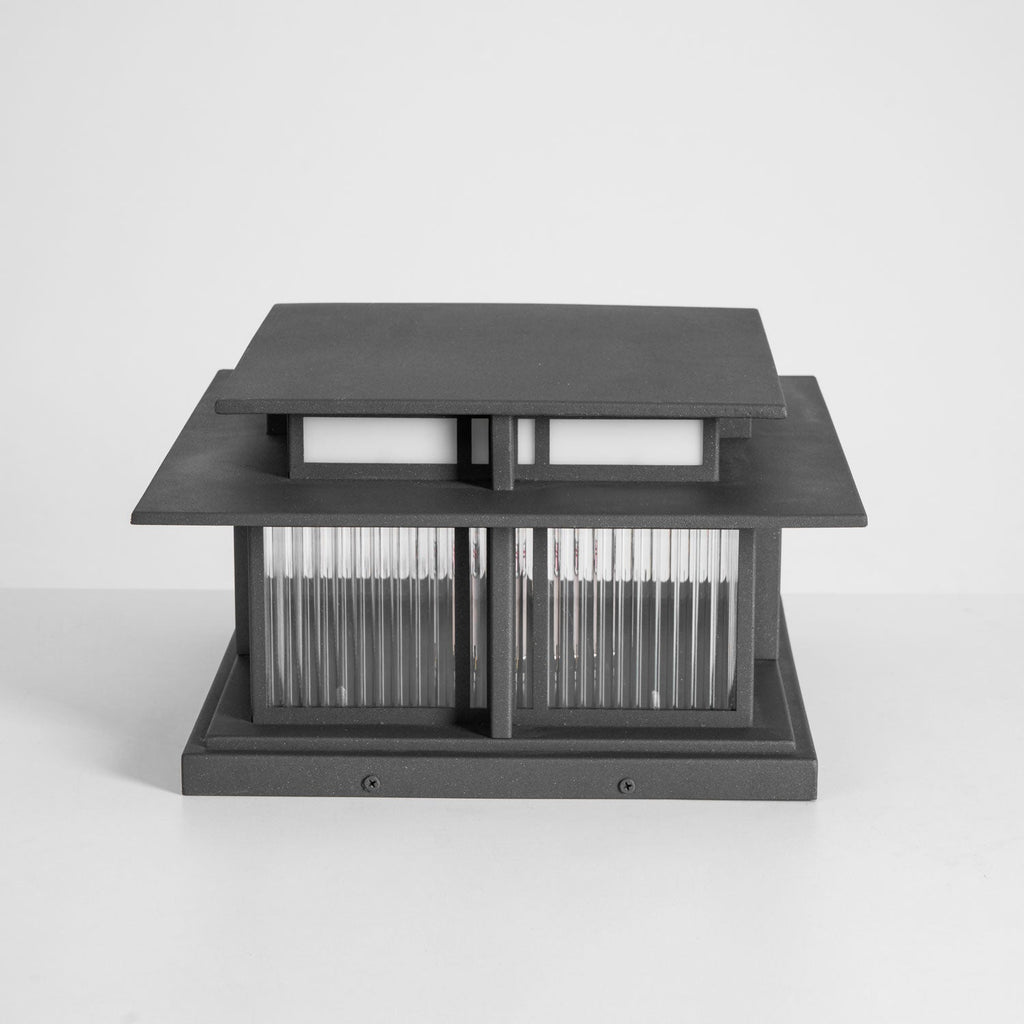 An unlit three-quarter view of this Clérachic pillar light on a grey studio backdrop, fluted glass panels pale and clear.
