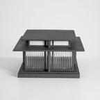 An unlit three-quarter view of this Clérachic pillar light on a grey studio backdrop, fluted glass panels pale and clear.