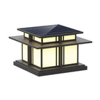 This lit Clérachic pillar light glows through frosted glass panels beneath its solar-panel roof, shown on white.