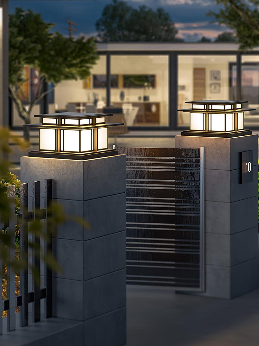 Two lit Clérachic pillar lights top textured concrete gate posts on either side of a slatted metal gate.
