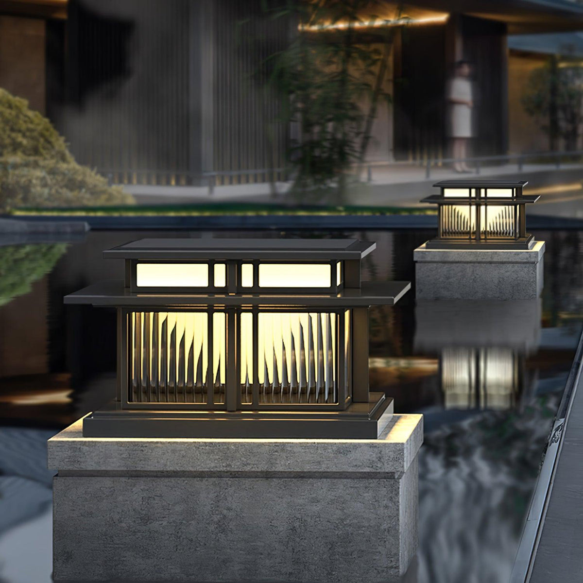 Fluted glass panels catch the light on this Clérachic pillar light, its reflection visible in the still water beside it.
