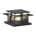 Unlit, this Clérachic pillar light stands on a white backdrop, its fluted glass panels set between dark frames.