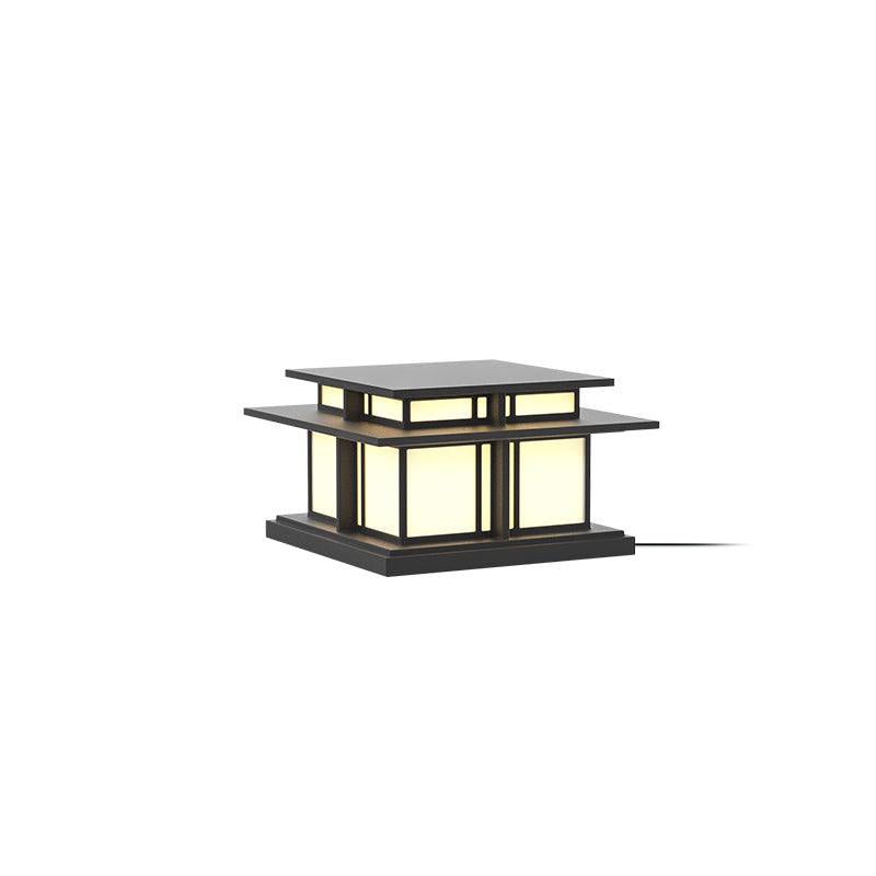 Lit against a white backdrop, this Clérachic pillar light glows through its frosted glass panels, cable trailing from the base.